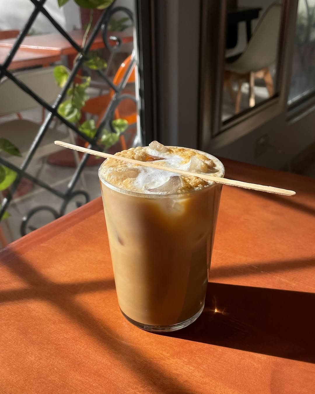 Café frío con espuma cremosa servido en vaso alto